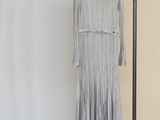 La robe est suspendue à un porte-vêtements dans la pièce.