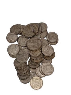 a pile of old silver coins on a white surface
