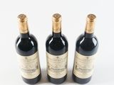 three bottles of wine sitting next to each other on a white surface