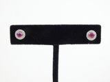 pair of ruby and diamond stud earrings on a black velvet stand