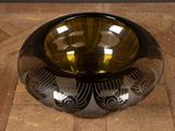 a black and gold bowl sitting on a wooden table