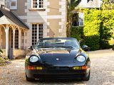 a black sports car parked in front of a large house