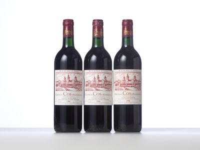 three bottles of red wine sitting on top of a white table