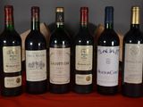six bottles of wine are lined up on a red table cloth