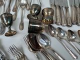 many spoons and forks laid out on the table