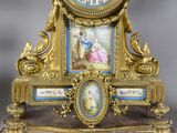a gold clock with a picture of a woman on it