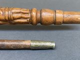 a wooden stick with a carved figure on it and a wooden stick with a carved figure on it