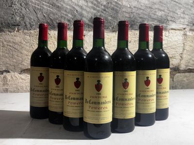six bouteilles de vin rouge alignées sur une table devant un mur de pierre