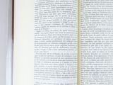 an open book sitting on top of a white table next to a cup of coffee