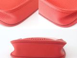 two pieces of red leather with holes on them