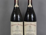two bottles of red wine sitting on top of a glass table