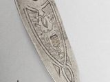 a silver spoon with a design on it sitting on a table