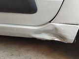 a close up of a white car with a denting on it