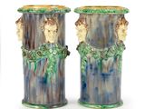 pair of blue and green vases with faces on them on a white background