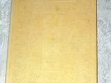 a yellow book on a bed with a white sheet