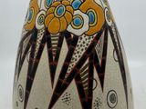 a vase with a design on it sitting on a table