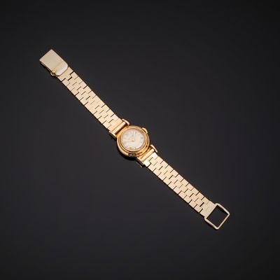 une montre en or avec un cadran blanc sur fond noir