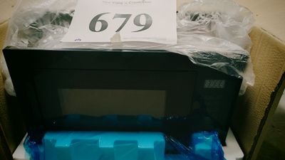 un micro-ondes dans un carton sur lequel est collée une étiquette de prix