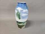 a blue vase with a painting of a tree on it
