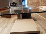 une table en verre avec un plateau en verre posée sur un sol carrelé