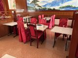 des tables et des chaises dans un restaurant où est accroché un grand tableau au mur