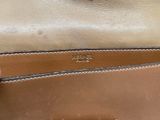 the inside of a tan purse with a brown handle
