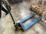 a blue hand truck that is sitting in a warehouse