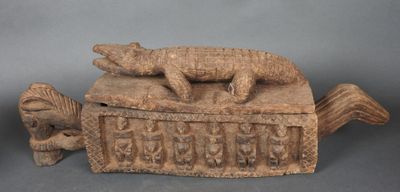 une image représentant une boîte en bois sur laquelle est posé un lézard