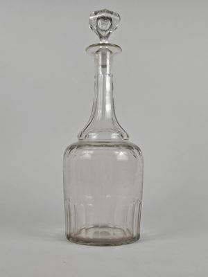 une carafe en verre à l'ancienne, munie d'un bouchon sur le dessus