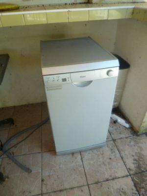 un lave-vaisselle blanc dans une cuisine sale