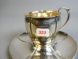 a silver cup and saucer on a saucer