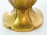 a gold vase sitting on top of a white table