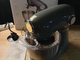 a blue mixer sitting on a wooden table next to a box