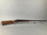 a rifle with a wooden barrel on a clear stand