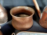 several copper pots and pans are sitting on a table