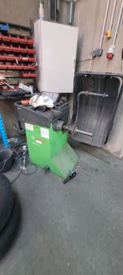 un tas de pneus dans un garage, à côté d'un réfrigérateur