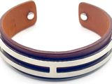 bracelet à manchette en cuir avec des rayures argentées et marron sur fond blanc