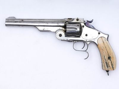 gros plan d'un revolver sur une surface blanche