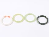 three pieces of green, white, and orange rubber rings on a white surface