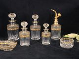 une image représentant un ensemble de bouteilles et de verres en verre sur fond noir