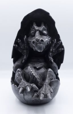 a statue of a dragon sitting on top of a bowl