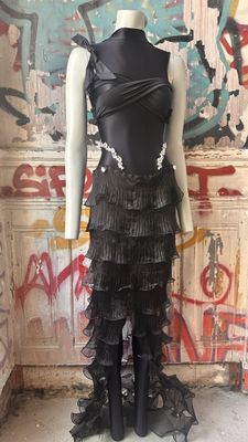 the mannequin is standing in front of a wall with graffiti on it