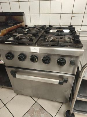 une cuisinière en acier inoxydable et un chariot dans une cuisine