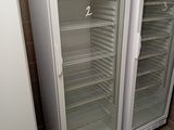 two refrigerators that are open in a room