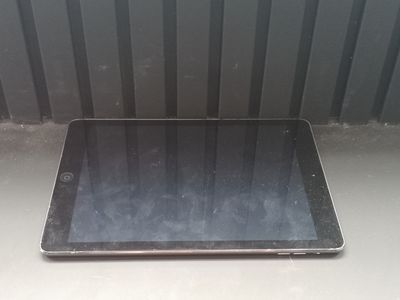 a tablet computer sitting on a table in front of a wall