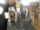 une photo d'une machine à café sur laquelle est posé un bocal rempli de pièces de monnaie