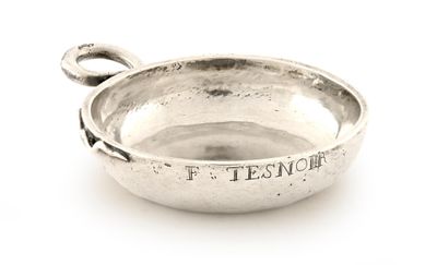 un petit bol en argent avec une poignée sur une surface blanche