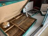 un coffret vert contenant de l'argenterie sur une table