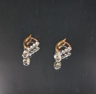 une paire de boucles d'oreilles en or et diamants sur une surface noire