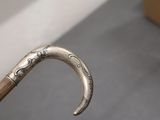 a close up of a silver and wood walking stick